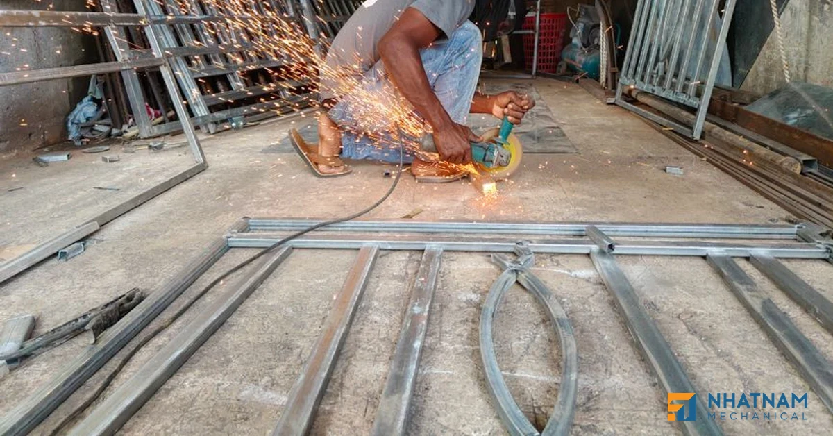 Hình ảnh xưởng gia công kim loại tấm truyền thống với thợ đang uốn kim loại thủ công
